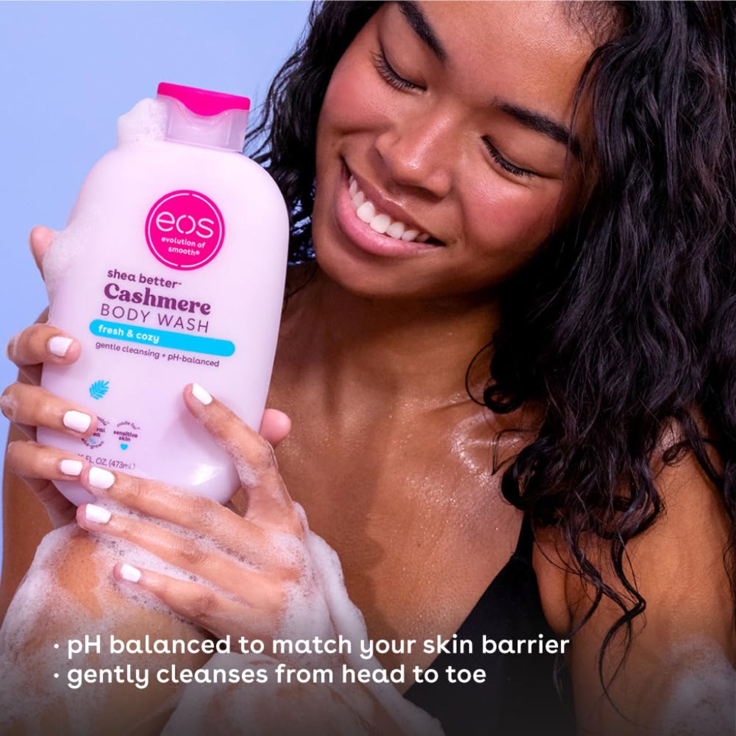 Woman holding eos Cashmere Body Wash with a blue background