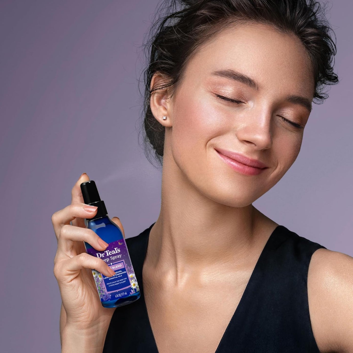 Woman holding a Dr. Teal's skincare product against a purple background