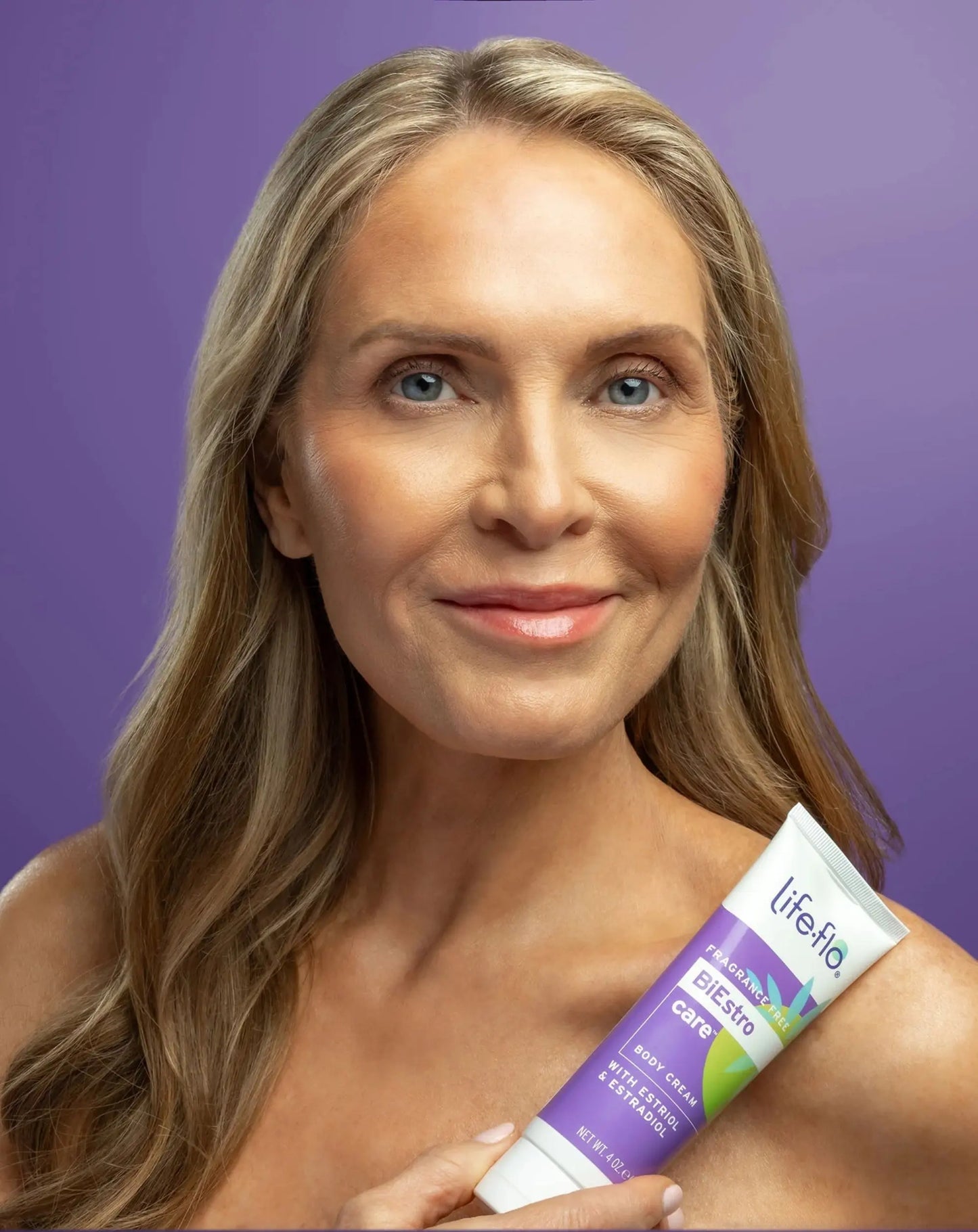 Woman holding a LifeFlo product against a purple background