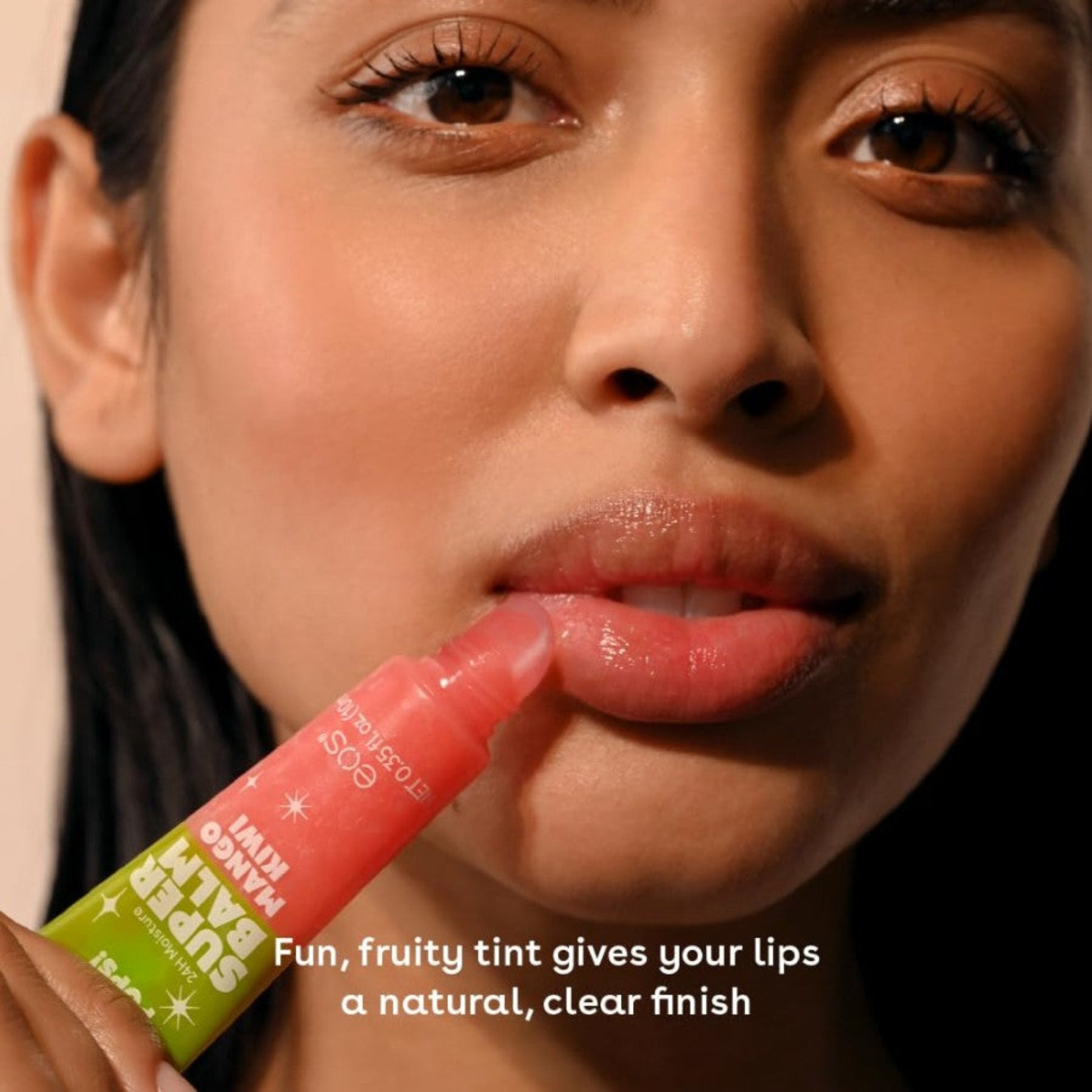 Woman applying a pink lip balm with text about its effects on lips.